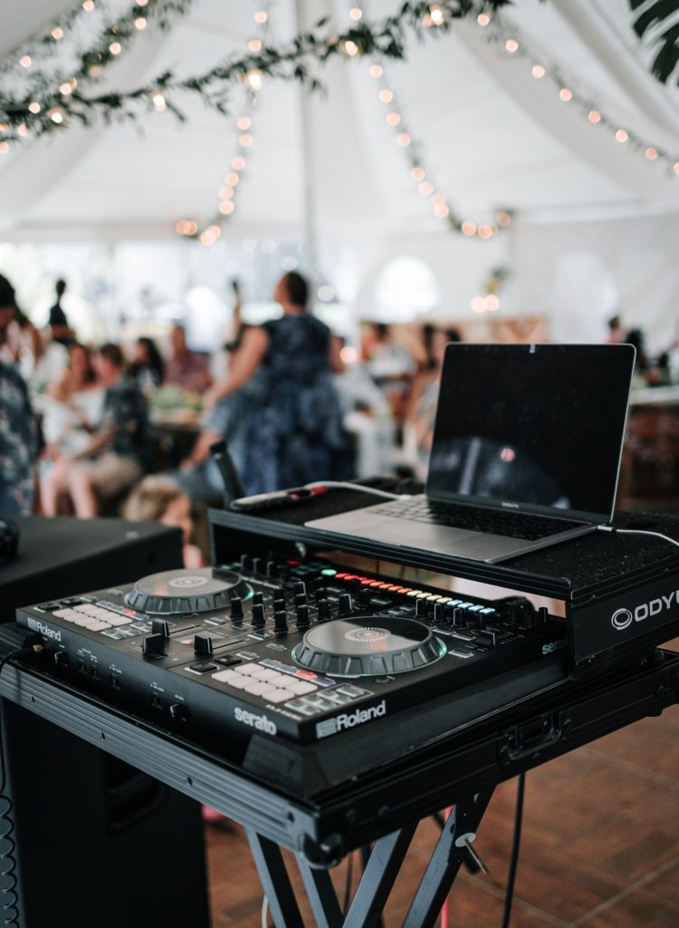 Table de mixage d'un DJ au premier plan d'une fête de mariage