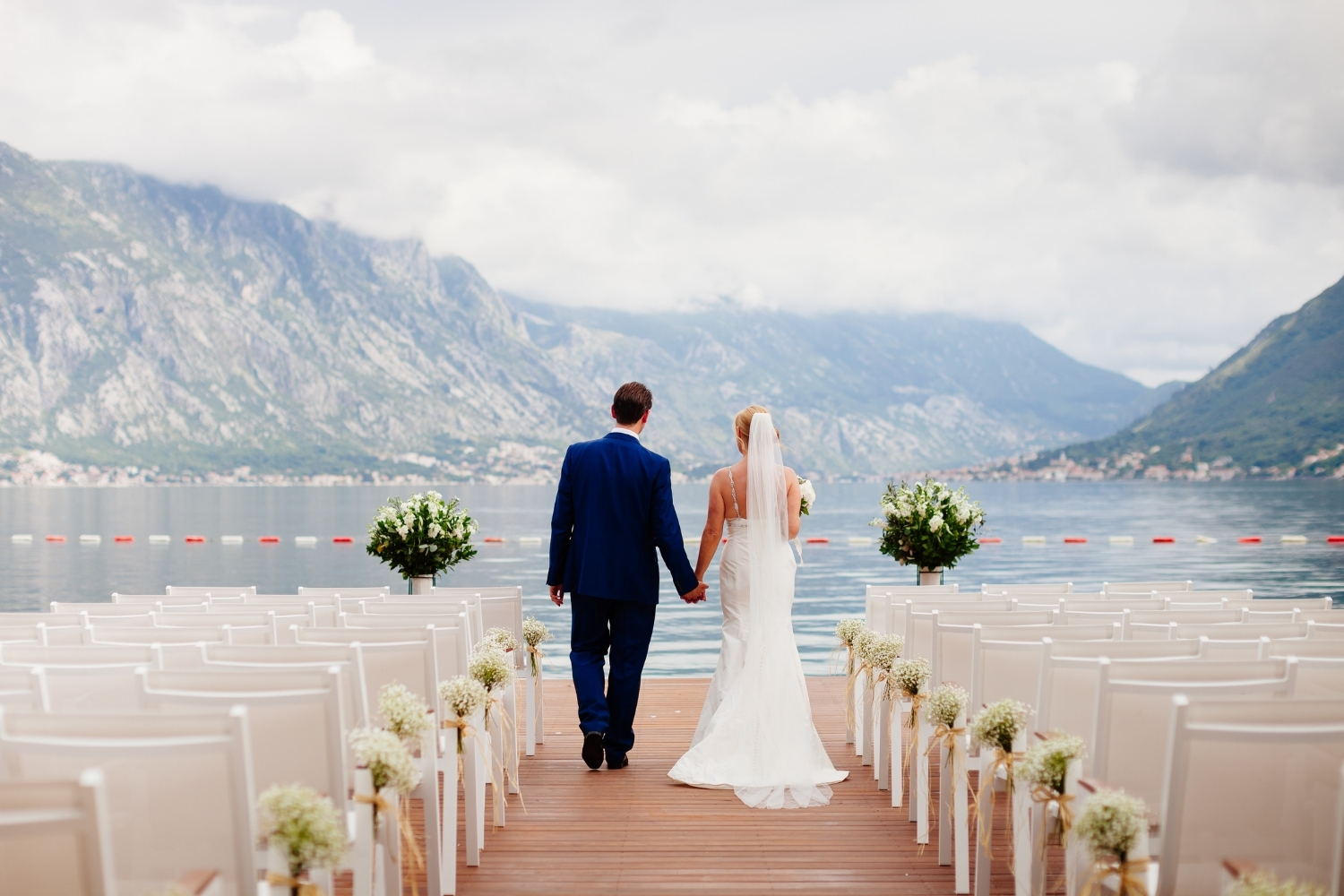cérémonie laïque avec les mariés que se tiennent la main face à un lac de montagne