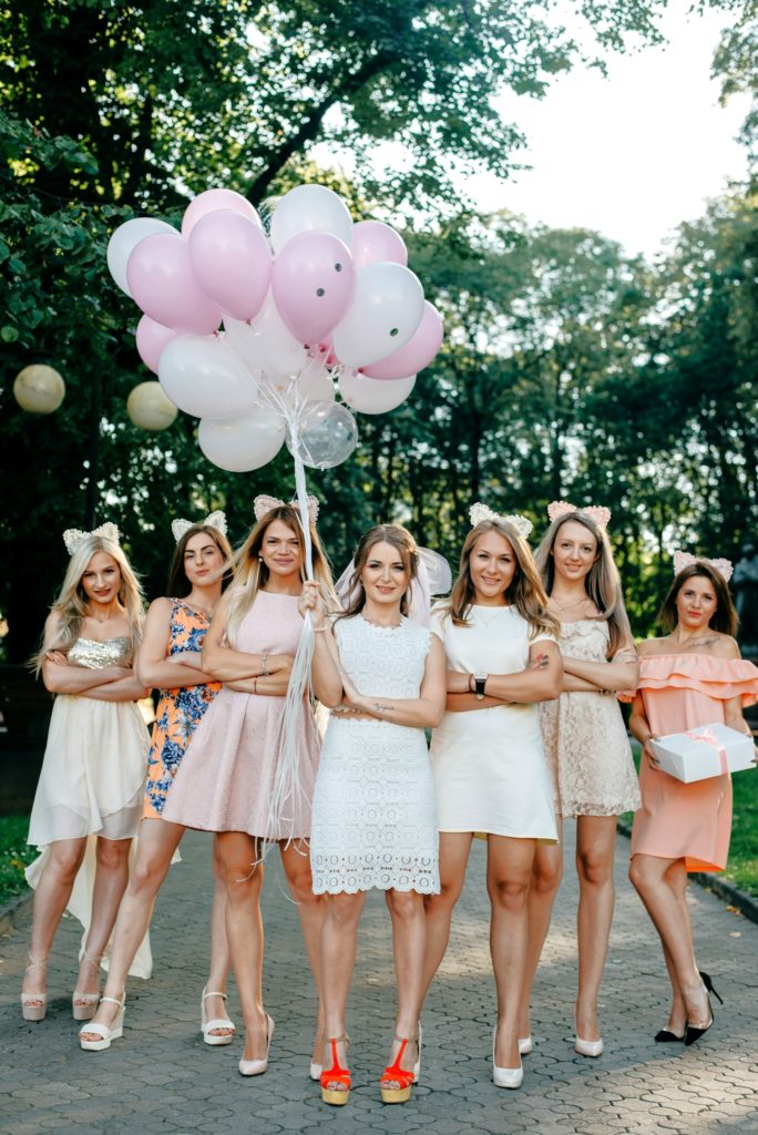 La mariée et ses demoiselles d'honneur avec des ballons roses et blancs.