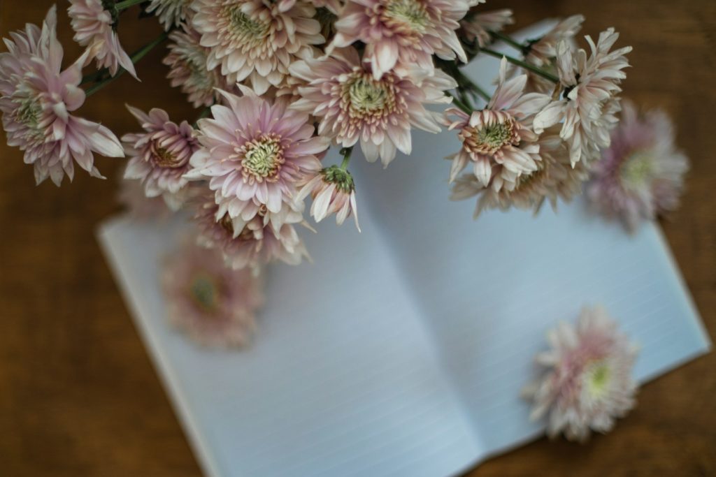 Bouquet de fleurs roses sur un cahier d'écriture blanc