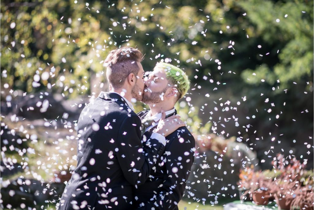 Couple gay qui échange son premier baiser au cours d'une cérémonie laïque de mariage.